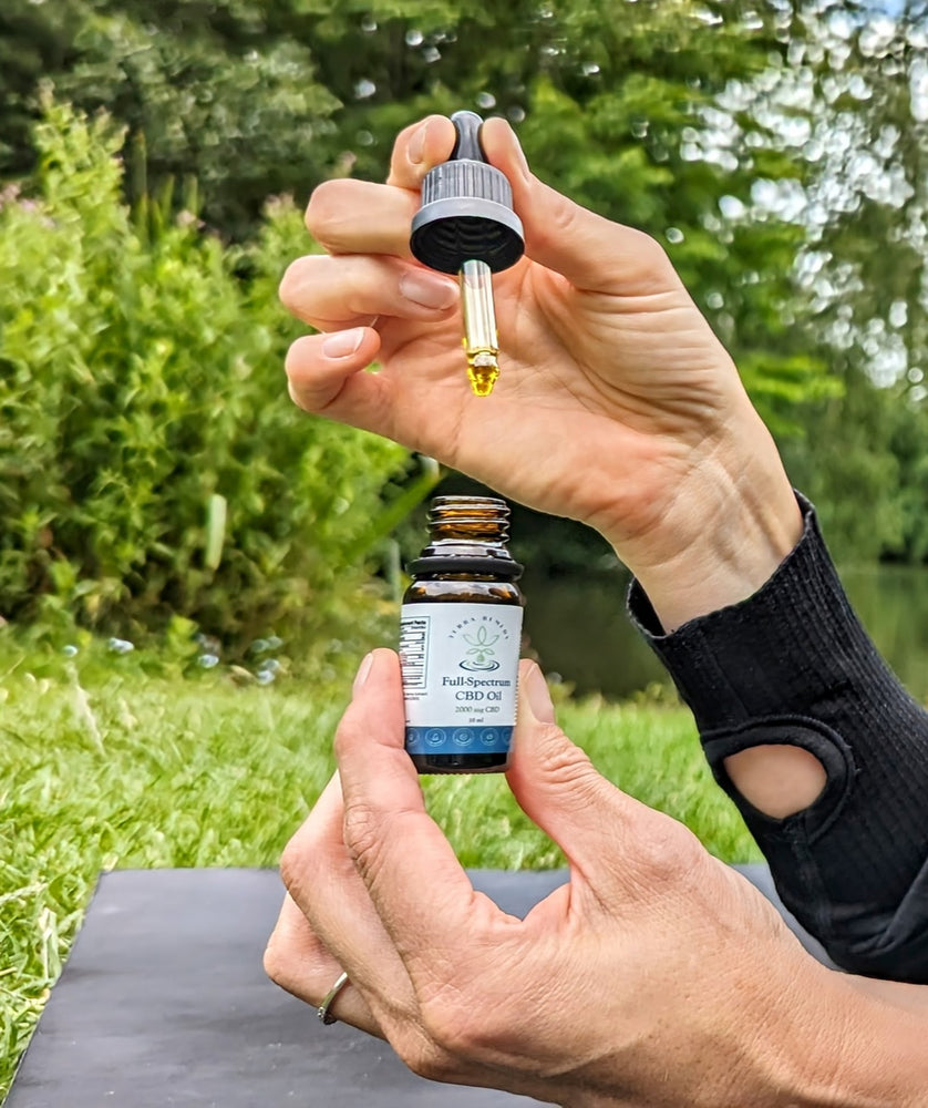 
                  
                    Close-up of a person holding a dropper of Terra Remedy Full-Spectrum CBD Oil. The bottle and dropper showcase the golden CBD oil, emphasizing its purity and natural ingredients for daily wellness.
                  
                