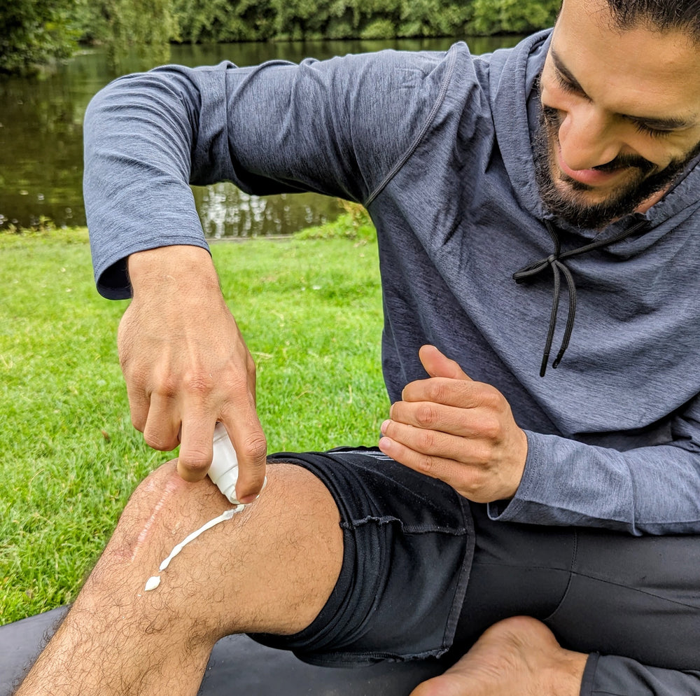 A person applying Terra Remedy Muscle Relief CBD Gel to their knee. The gel, infused with 500 mg of CBD, provides a cooling sensation to relieve muscle pain and soreness, ideal for post-workout recovery.