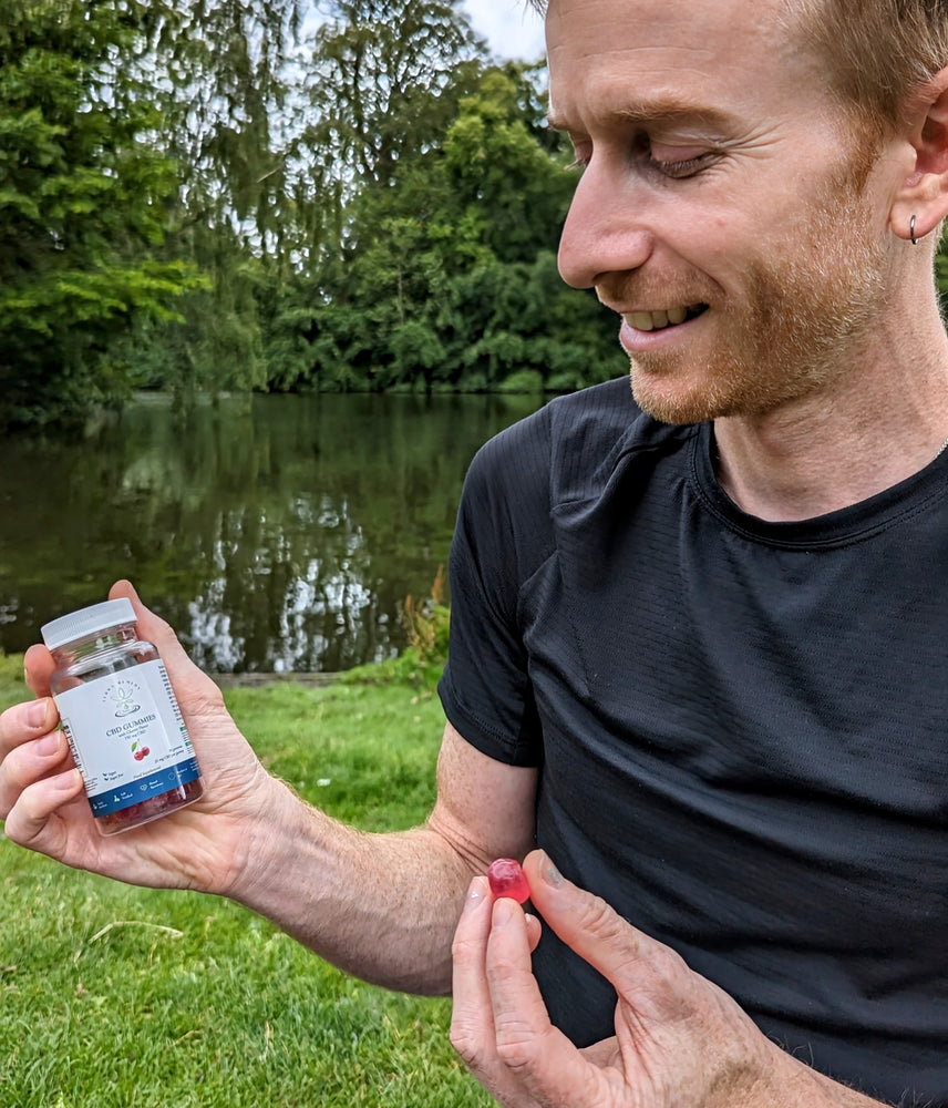 
                  
                    A person holding a bottle of Terra Remedy cherry-flavored CBD gummies in one hand and a single gummy in the other. The gummies are vegan, sugar-free, and contain broad-spectrum CBD for a tasty and convenient wellness option.
                  
                